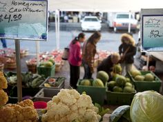 people shopping at an outdoor farmers market