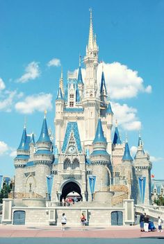 a large castle with many towers and people walking around it