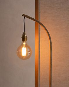 a light that is sitting on top of a table next to a lamp shade and a wall