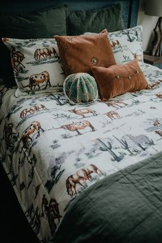 a bed with two pillows on top of it and an elephant pillow sitting on the bottom