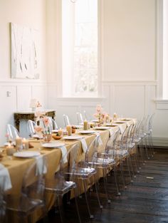 a long table is set up with clear chairs