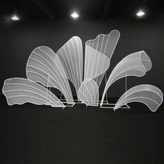 an abstract sculpture in the middle of a dark room with two lights on each side