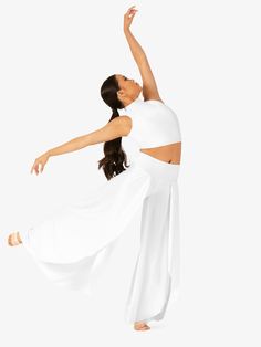 a woman in white is dancing with her arms spread out to the side and she has one leg up