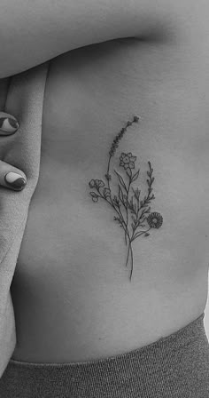 a woman's stomach with a flower tattoo on her belly and the bottom part of her stomach