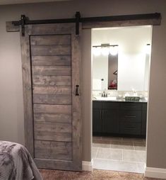 an image of a bedroom with a sliding barn door in the middle and a bathroom on the other side