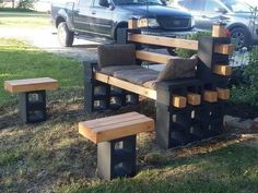 an outdoor bench made out of wood and concrete blocks, with two benches on each side