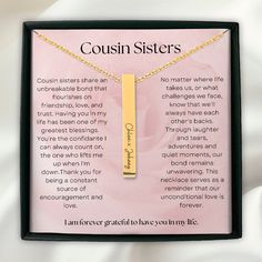 a gold bar necklace with the words coun sisters on it in front of a pink background