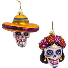 two skulls wearing sombreros and hats are hanging from strings in the shape of christmas ornaments