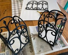 two iron heart shaped baskets sitting on top of a wooden table