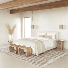 a large white bed sitting in a bedroom next to a window