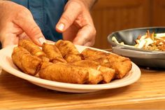 a man is cutting up some food on a plate next to a bowl of salad