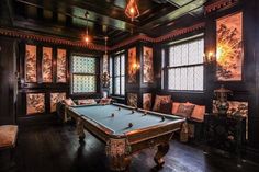 a pool table in a room with many windows