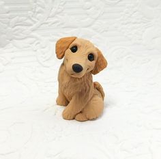 a brown dog figurine sitting on top of a white tablecloth covered floor