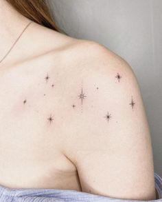 the back of a woman's shoulder with small stars on her left arm and chest