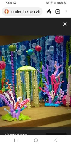 an underwater scene made out of plastic cups and straws is shown on the phone screen