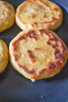 four pancakes sitting on top of a black plate