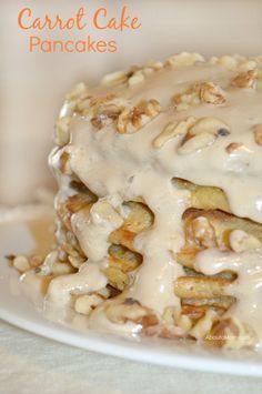 carrot cake pancakes covered in icing and nuts on a white plate with text overlay