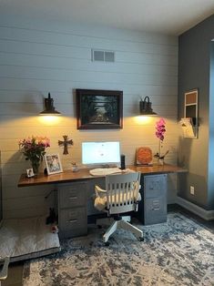 a desk with a computer on top of it in a room filled with furniture and decor