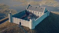 an aerial view of a castle with water surrounding it