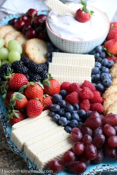 a blue plate topped with fruit and crackers