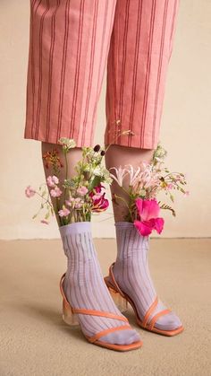 the legs and ankles of a person wearing pink socks with flowers in their sock holders