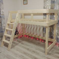 a wooden bunk bed sitting on top of a hard wood floor next to a christmas tree