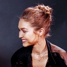 a woman with her hair in a bun smiling