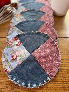 a close up of a patchwork plate on a wooden table with an apple in the background