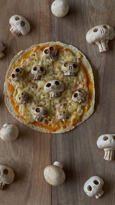 a pizza sitting on top of a wooden table covered in skulls