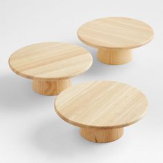 two round wooden tables sitting next to each other on a white surface with no one around them