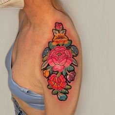 a woman's shoulder with a colorful tattoo design on her left arm and chest