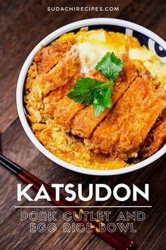 a bowl filled with fried meat and rice next to chopsticks on a wooden table