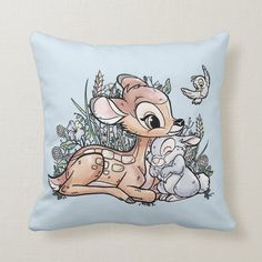 a blue pillow with an image of a baby deer sitting on it's back