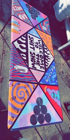 a colorful kite is hanging on the side of a building with graffiti all over it