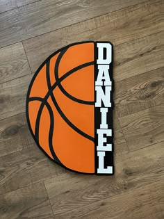 an orange and black basketball with the word dannel on it is laying on a wood floor