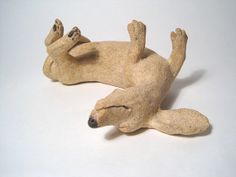 a statue of a dog laying on its back with it's paws up in the air