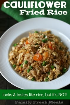 a white bowl filled with rice and vegetables on top of a green table cloth next to a