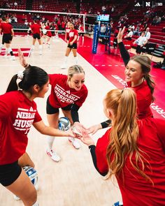 the women's volleyball team huddles together on the court to congratulate each other