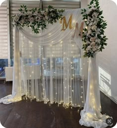 a wedding arch decorated with white flowers and greenery