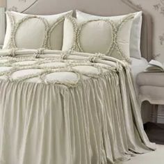 the comforter is made up with ruffled sheets and pillowcases, along with decorative wallpaper