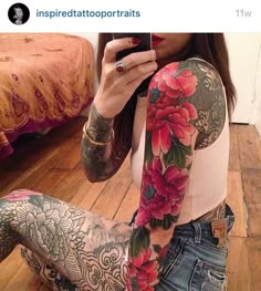 a woman is taking a selfie with her cell phone and tattoos on her arm