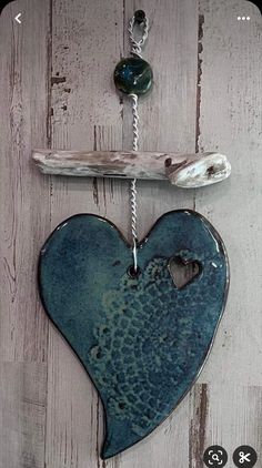 a blue heart hanging on the side of a wooden wall