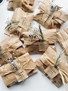 several wrapped gift bags with thank you written on them and tied with twine ribbons