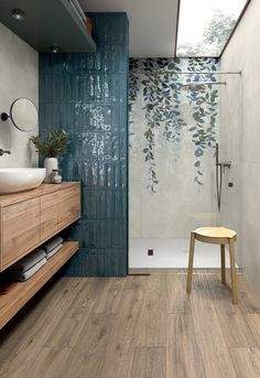 a bathroom with wood flooring and blue tiles on the walls, along with a wooden stool