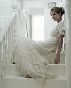 a woman in a white dress sitting on some stairs