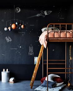 a child's bedroom with a space theme painted on the wall and bunk bed