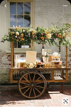 a wooden cart with flowers and drinks on it