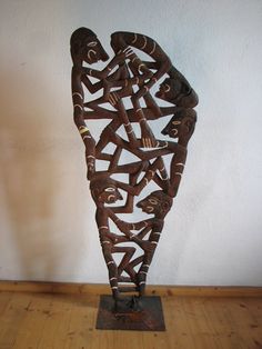 a sculpture made out of wooden sticks on top of a wooden floor next to a white wall