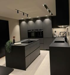 a modern kitchen with black cabinets and counter tops