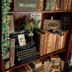 an old fashioned typewriter sitting on top of a book shelf